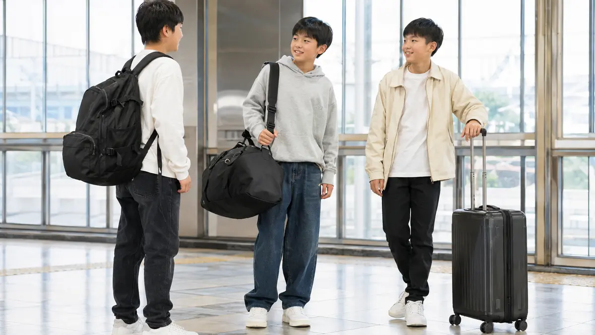 リュックとボストンバッグとキャリーケースを持つ日本人の中学生