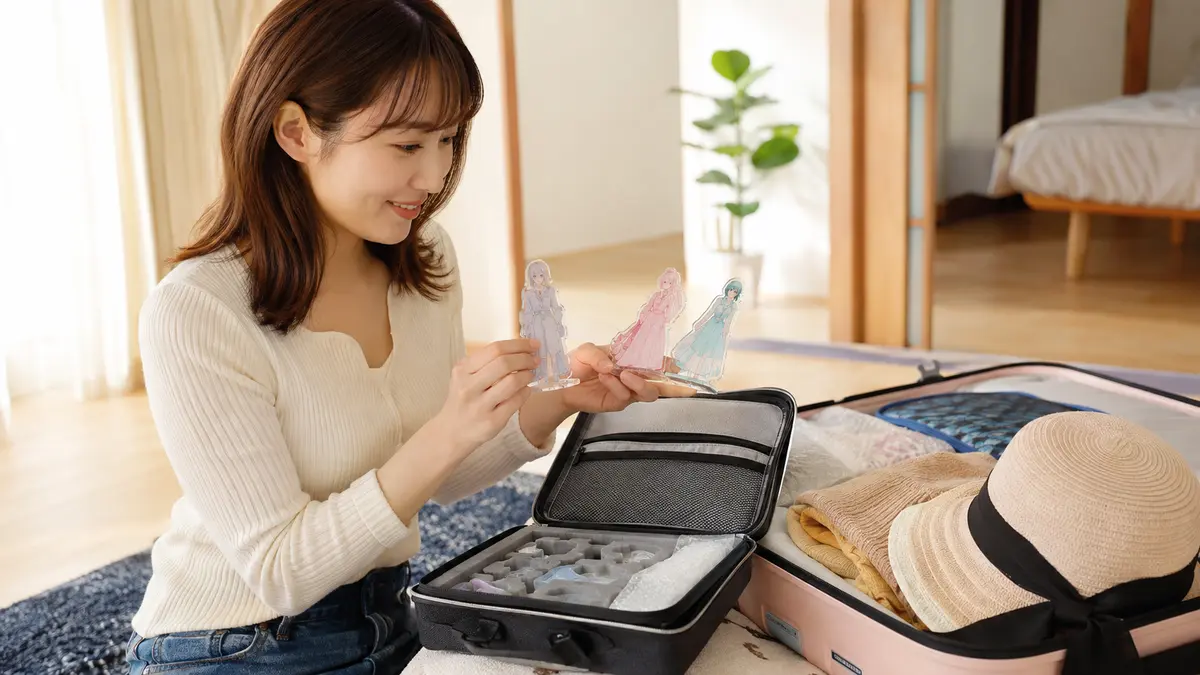 旅行後に傷や割れのないアクリルスタンドを確認する日本人女性